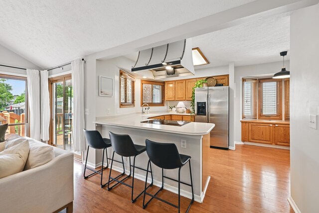 12231 Binney St, Omaha, NE 68164 - kitchen featuring stainless steel refrigerator with ice dispenser, a textured ceiling, a peninsula, a kitchen bar, and a sink