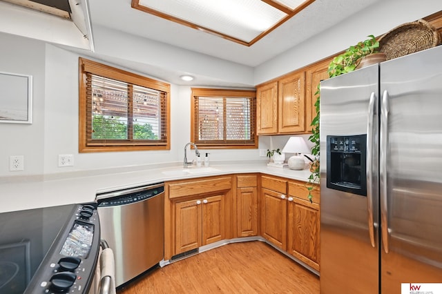 12231 Binney St, Omaha, NE 68164 - kitchen with appliances with stainless steel finishes, a sink, light wood-style flooring, and light countertops