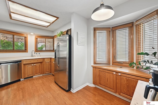 12231 Binney St, Omaha, NE 68164 - kitchen featuring appliances with stainless steel finishes, brown cabinets, a sink, and light countertops