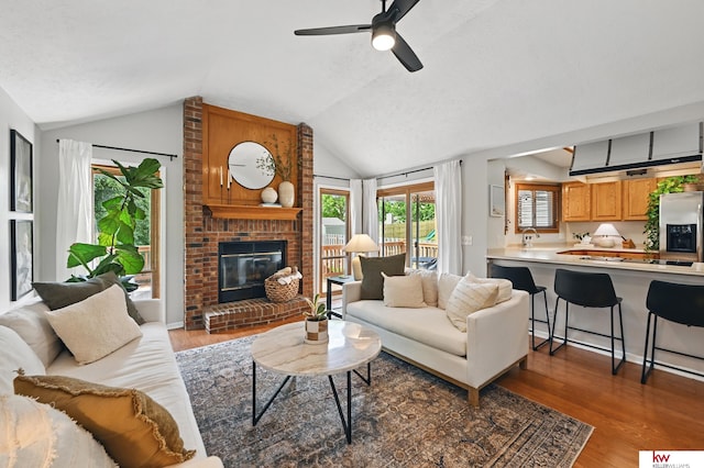 12231 Binney St, Omaha, NE 68164 - living area featuring lofted ceiling, wood finished floors, a fireplace, ceiling fan, and a textured ceiling