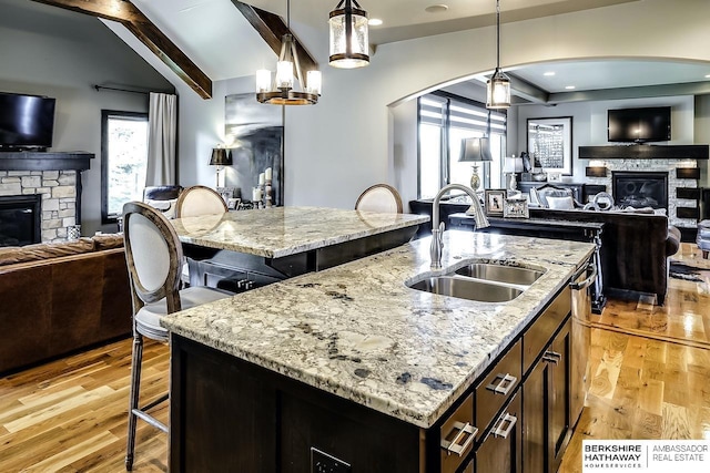 3334 S 188th Ave, Omaha, NE 68130 - kitchen with a fireplace, open floor plan, a sink, and a kitchen island with sink