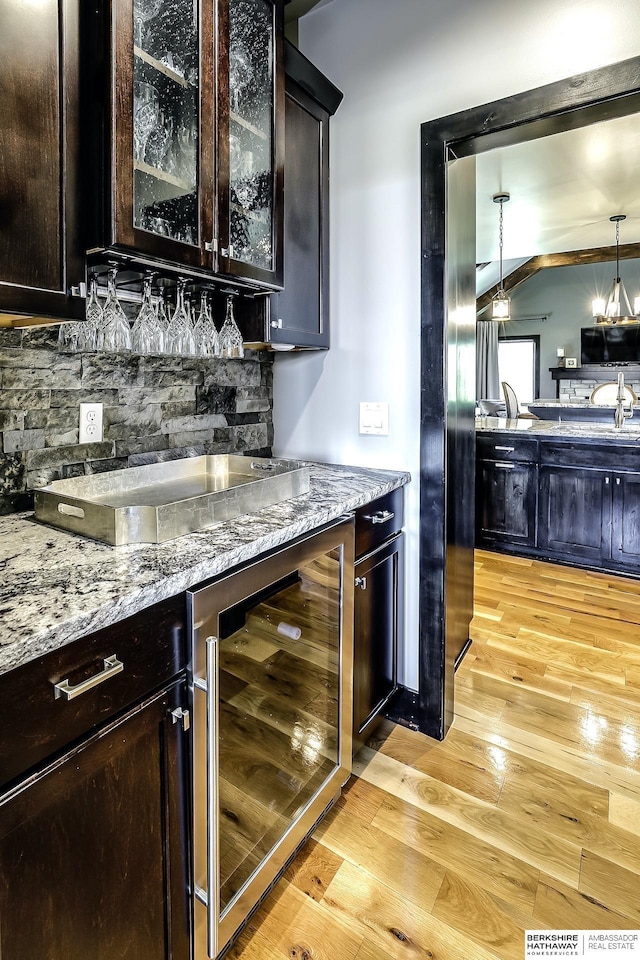 3334 S 188th Ave, Omaha, NE 68130 - indoor bar featuring beverage cooler, light wood finished floors, tasteful backsplash, and pendant lighting