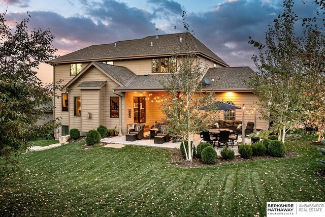 3334 S 188th Ave, Omaha, NE 68130 - back of property at dusk with a patio area, outdoor lounge area, and a yard