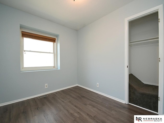 6115 S 115th St, Omaha, NE 68137 - unfurnished bedroom featuring dark wood-type flooring, a closet, and baseboards