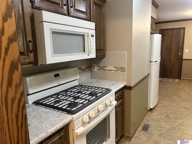 5418 Thies Cove Dr, Lincoln, NE 68516 - kitchen with white appliances, dark brown cabinetry, light countertops, light flooring, and crown molding