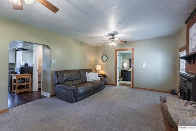 605 2nd St, Waterloo, NE 68069 - carpeted living area with ceiling fan, arched walkways, baseboards, and a textured ceiling
