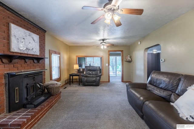 605 2nd St, Waterloo, NE 68069 - carpeted living room featuring arched walkways, a ceiling fan, a fireplace, and baseboards
