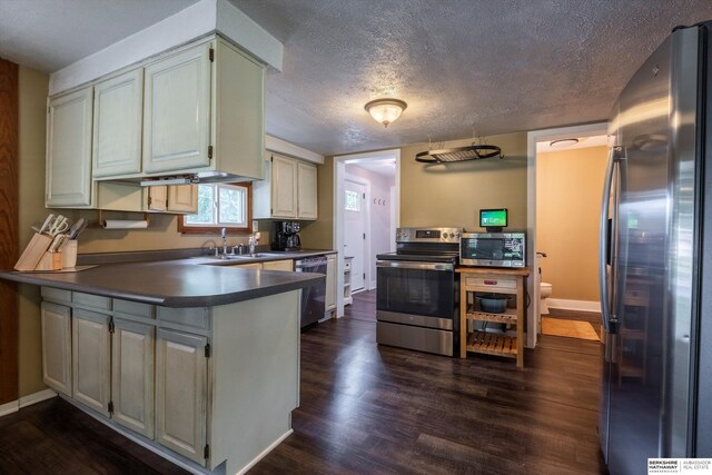 605 2nd St, Waterloo, NE 68069 - kitchen with stainless steel appliances, a sink, dark wood-type flooring, dark countertops, and a peninsula