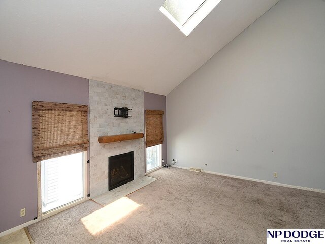 12067 Patrick Ave, Omaha, NE 68164 - unfurnished living room with a large fireplace, a skylight, carpet flooring, baseboards, and high vaulted ceiling
