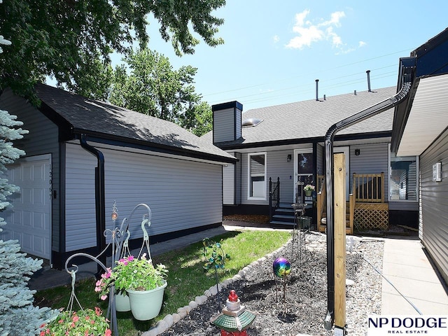 12067 Patrick Ave, Omaha, NE 68164 - view of front of house with a garage, an outdoor structure, a chimney, and roof with shingles