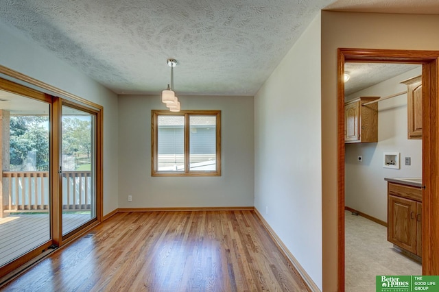 17139 S St, Omaha, NE 68135 - unfurnished dining area with light wood-type flooring, a textured ceiling, and baseboards