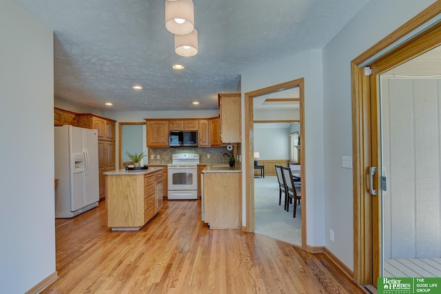 17139 S St, Omaha, NE 68135 - kitchen with white appliances, a sink, a kitchen island, light wood finished floors, and light countertops