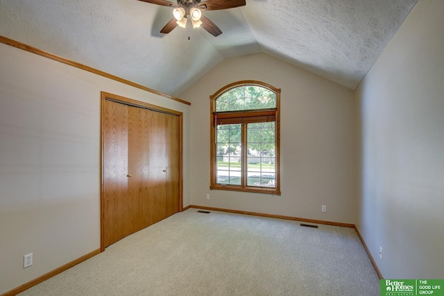 17139 S St, Omaha, NE 68135 - unfurnished bedroom featuring a textured ceiling, vaulted ceiling, carpet, baseboards, and ceiling fan