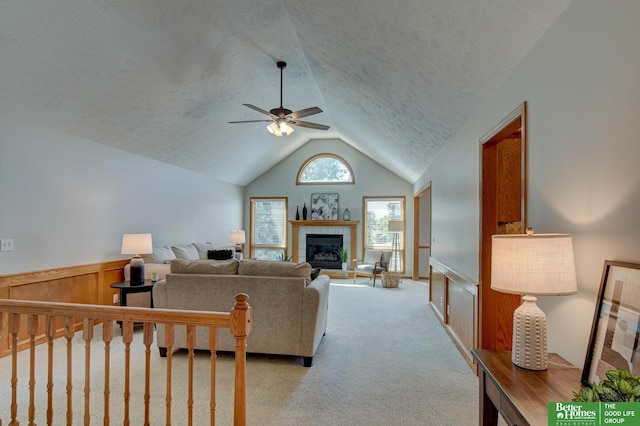 17139 S St, Omaha, NE 68135 - carpeted living area featuring ceiling fan, vaulted ceiling, a fireplace, and a textured ceiling