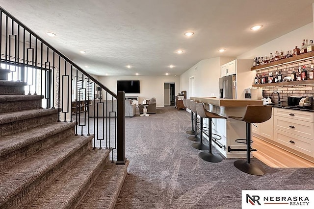 11473 S 189th St, Gretna, NE 68028 - indoor wet bar featuring high end refrigerator, light carpet, stairway, recessed lighting, and baseboards
