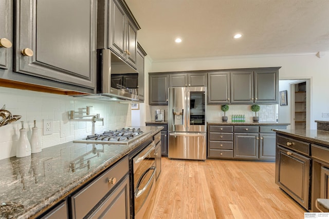 3814 S 186th Ave, Omaha, NE 68130 - kitchen featuring stainless steel appliances, crown molding, tasteful backsplash, light wood-style flooring, and dark stone countertops