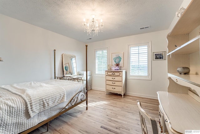 3814 S 186th Ave, Omaha, NE 68130 - bedroom with a chandelier, light wood-style floors, a textured ceiling, and baseboards