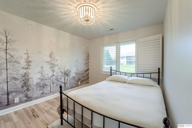 3814 S 186th Ave, Omaha, NE 68130 - bedroom featuring wood finished floors, a chandelier, and baseboards