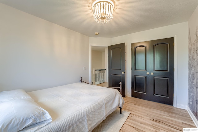 3814 S 186th Ave, Omaha, NE 68130 - bedroom featuring light wood-style floors, a chandelier, a closet, and baseboards