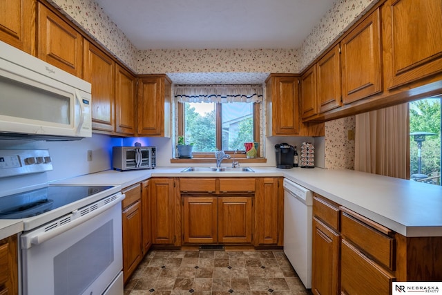 9910 Ohio St, Omaha, NE 68134 - kitchen featuring white appliances, a sink, brown cabinetry, and light countertops