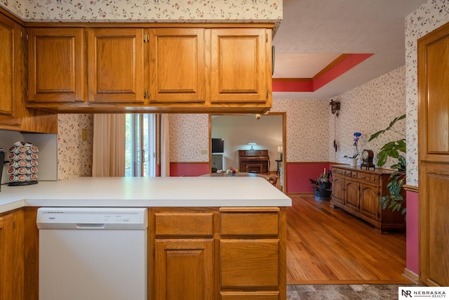 9910 Ohio St, Omaha, NE 68134 - kitchen with dishwasher, wallpapered walls, a peninsula, a wainscoted wall, and brown cabinets