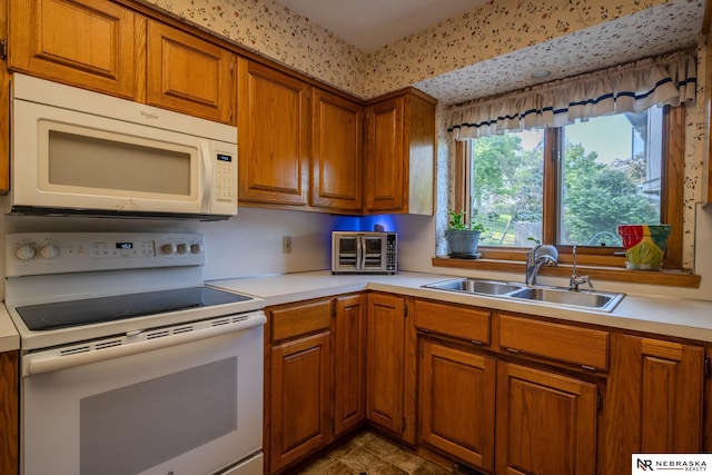 9910 Ohio St, Omaha, NE 68134 - kitchen with white appliances, a sink, brown cabinets, and light countertops