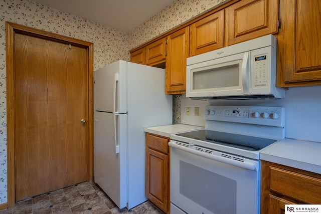 9910 Ohio St, Omaha, NE 68134 - kitchen with white appliances, brown cabinetry, and light countertops
