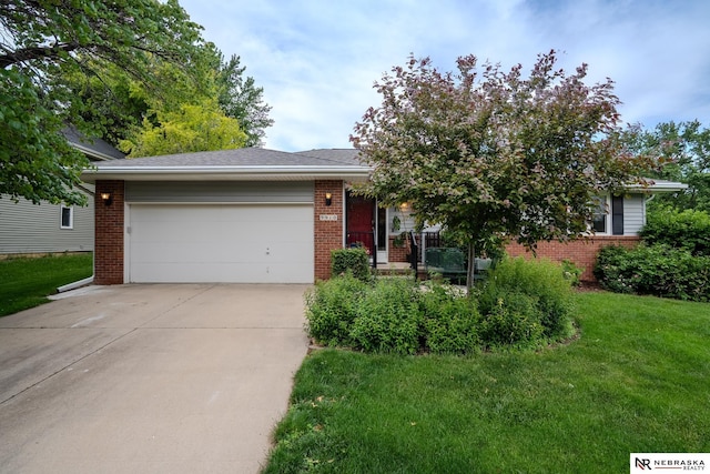 9910 Ohio St, Omaha, NE 68134 - view of property hidden behind natural elements with brick siding, concrete driveway, an attached garage, and a front lawn