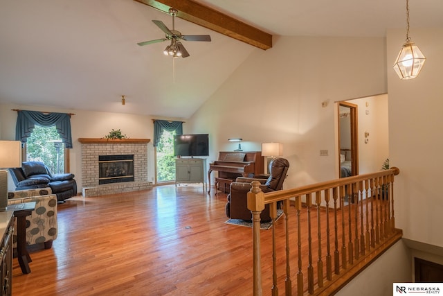9910 Ohio St, Omaha, NE 68134 - living area featuring beamed ceiling, ceiling fan, a brick fireplace, wood finished floors, and high vaulted ceiling