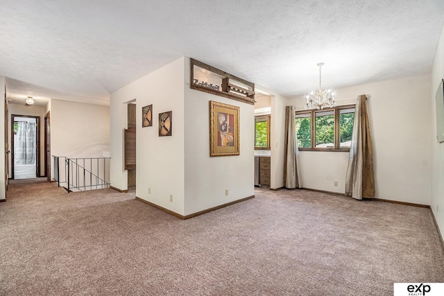 1214 Happy Hallow Ct, Plattsmouth, NE 68048 - empty room featuring carpet, a chandelier, baseboards, and a textured ceiling