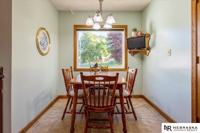 4542 Charles St, Omaha, NE 68132 - dining area featuring a chandelier, light tile patterned floors, and baseboards