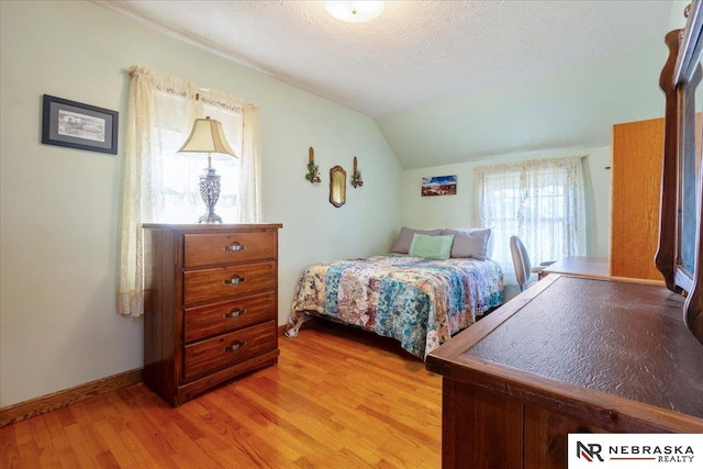 4542 Charles St, Omaha, NE 68132 - bedroom featuring light wood-style flooring, vaulted ceiling, a textured ceiling, and baseboards