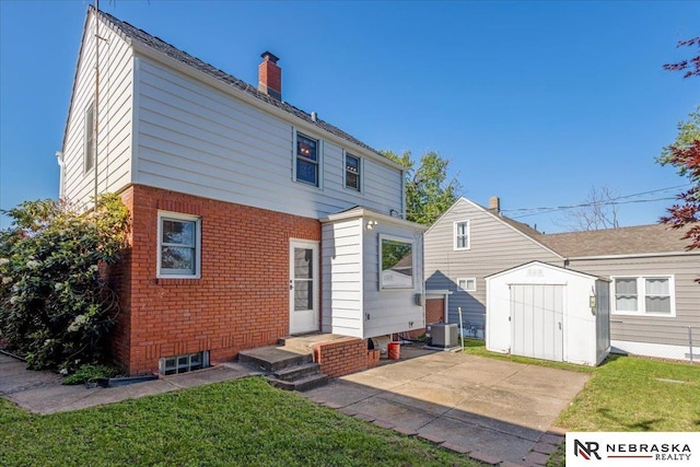4542 Charles St, Omaha, NE 68132 - rear view of property featuring a chimney, brick siding, a yard, and central AC unit