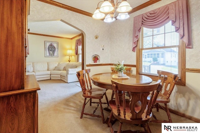 4542 Charles St, Omaha, NE 68132 - dining area featuring ornamental molding, arched walkways, a chandelier, and light colored carpet
