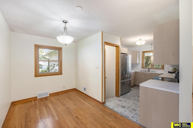 1341 Wilbur St, Blair, NE 68008 - kitchen with stainless steel refrigerator with ice dispenser, electric range oven, light countertops, a sink, and light wood-style flooring