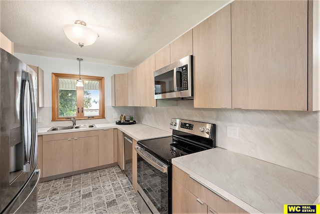 1341 Wilbur St, Blair, NE 68008 - kitchen with appliances with stainless steel finishes, light brown cabinetry, a sink, light countertops, and a textured ceiling