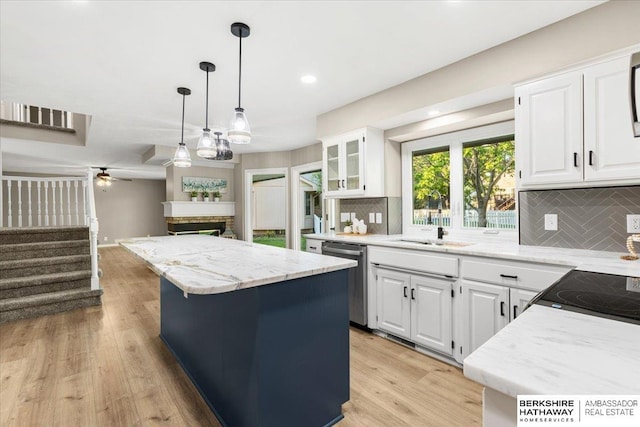 16324 Chicago St, Omaha, NE 68118 - kitchen with dishwasher, a kitchen island, a fireplace, decorative backsplash, and white cabinets