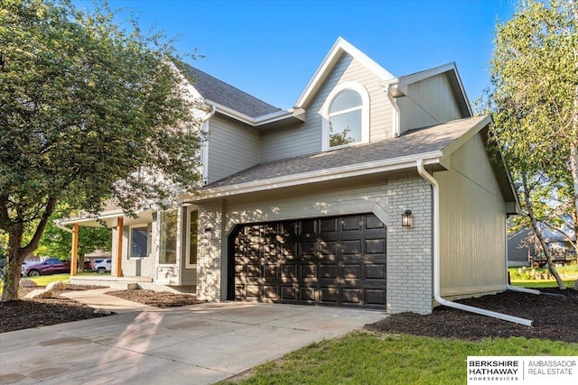 16324 Chicago St, Omaha, NE 68118 - view of front of property with brick siding, a shingled roof, concrete driveway, and an attached garage