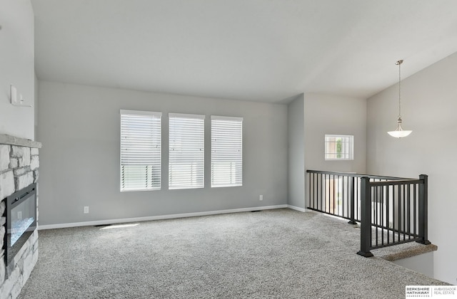 7164 N 167th St, Bennington, NE 68007 - unfurnished living room with carpet flooring, a fireplace, vaulted ceiling, and baseboards