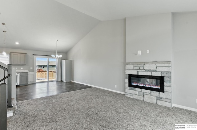 7164 N 167th St, Bennington, NE 68007 - unfurnished living room featuring dark colored carpet, vaulted ceiling, a chandelier, baseboards, and a stone fireplace