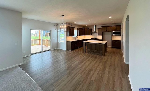 4618 N 212th St, Elkhorn, NE 68022 - kitchen with stainless steel microwave, wall chimney range hood, a sink, open floor plan, and dark wood-style flooring