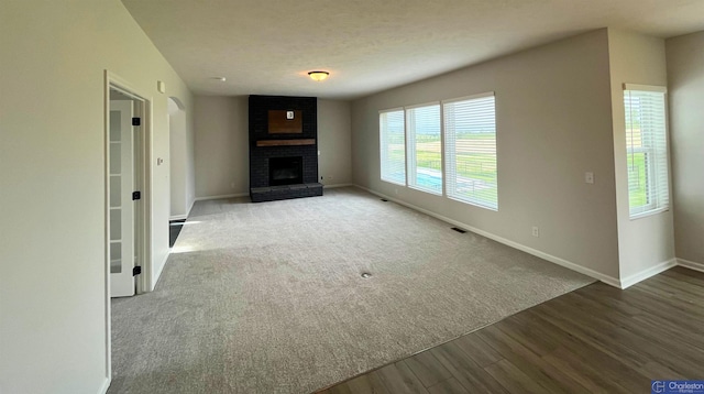 4618 N 212th St, Elkhorn, NE 68022 - unfurnished living room with wood finished floors, baseboards, and a brick fireplace