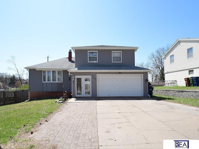 2103 Randall Dr, Bellevue, NE 68005 - split level home featuring an attached garage, concrete driveway, a shingled roof, and french doors