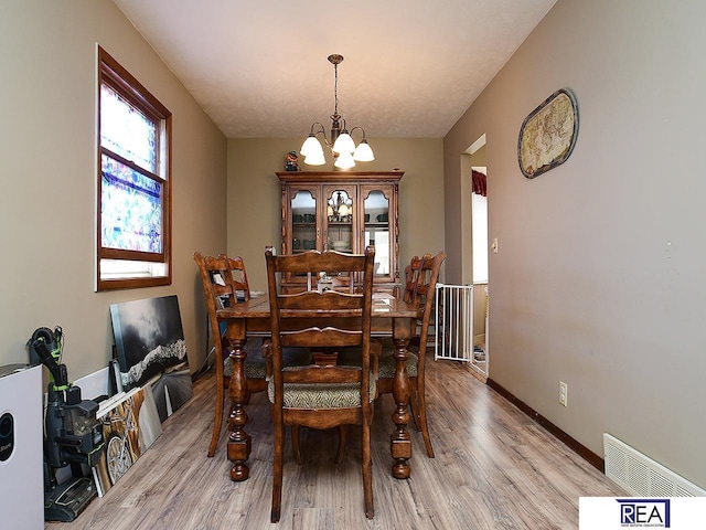 2103 Randall Dr, Bellevue, NE 68005 - dining area with a chandelier, light wood-style floors, and baseboards
