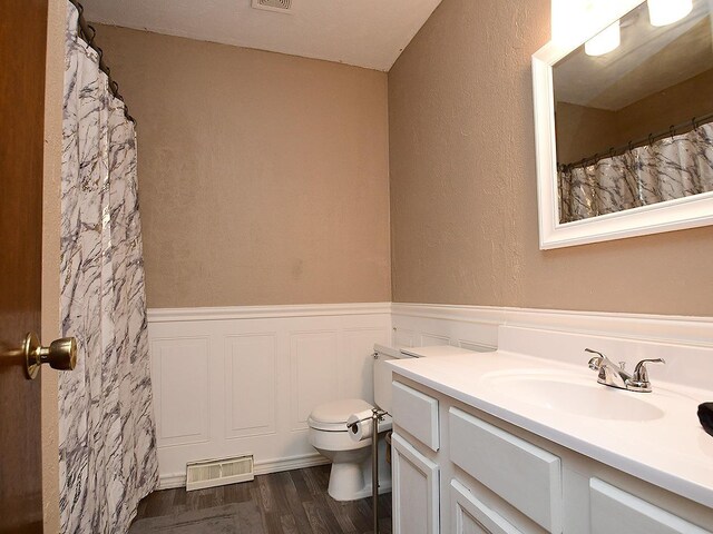 2103 Randall Dr, Bellevue, NE 68005 - full bathroom featuring vanity, wood finished floors, wainscoting, and toilet