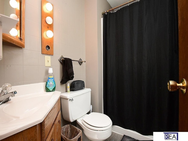 2103 Randall Dr, Bellevue, NE 68005 - bathroom with vanity, toilet, tile walls, curtained shower, and tasteful backsplash