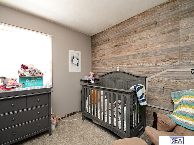 2103 Randall Dr, Bellevue, NE 68005 - carpeted bedroom with wood walls and a nursery area
