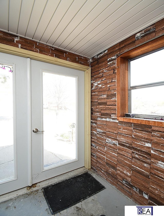 2103 Randall Dr, Bellevue, NE 68005 - doorway to outside with plenty of natural light, unfinished concrete floors, and wood walls