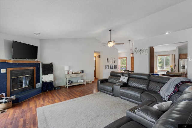 2706 Overlook Cir, Plattsmouth, NE 68048 - living room featuring wood finished floors, ceiling fan, vaulted ceiling, and a glass covered fireplace