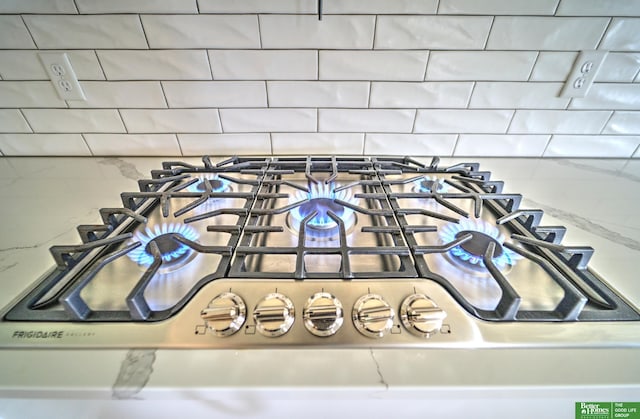 12369 Cooper St, Papillion, NE 68046 - kitchen view of decorative backsplash, stainless steel gas cooktop, and stone countertops